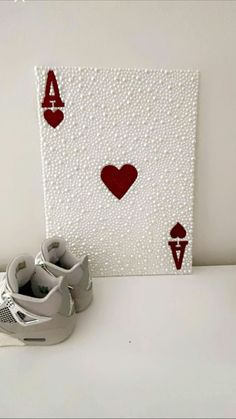 a pair of shoes sitting on top of a table next to a card with hearts