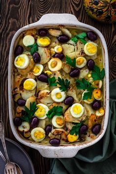 a casserole dish filled with eggs and olives