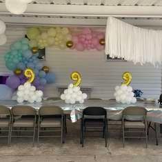 there is a table with balloons on it and some chairs in front of the table