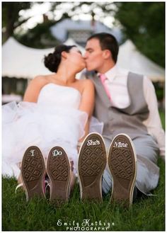 a bride and groom kissing in front of their wedding shoes