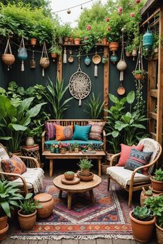 an outdoor living room with potted plants and furniture in the corner, along with hanging planters