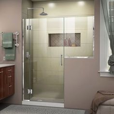 a bathroom with a walk in shower next to a sink and mirror on the wall