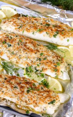 two fish fillets in foil with lemons and herbs