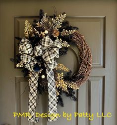 a wreath on the front door decorated with pine cones and plaid bows