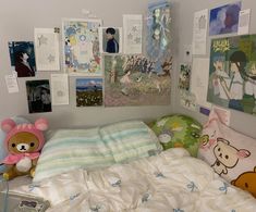 there is a bed with many pictures on the wall above it and a teddy bear