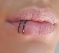 a woman's lip with two thin black rings on it