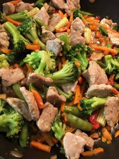 stir fry with broccoli, carrots, and meat in a wok