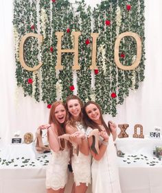 three young women standing next to each other in front of a sign that says chio