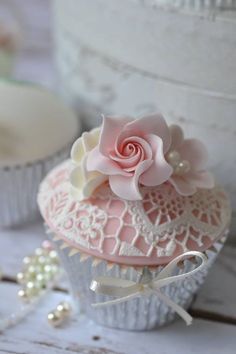 a pink cupcake sitting on top of a table