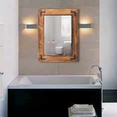 a bathroom with a bathtub, mirror and towel rack on the wall next to it