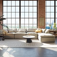 a living room with large windows and a sectional couch