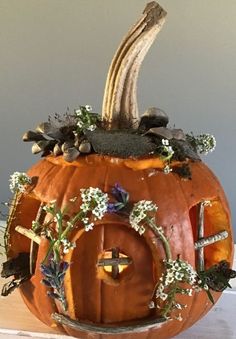 a pumpkin decorated with flowers and leaves