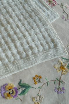 an embroidered blanket with flowers on it