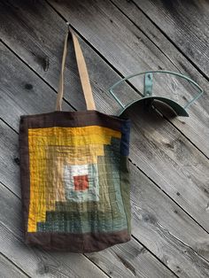 a tote bag sitting on top of a wooden floor next to a pair of glasses