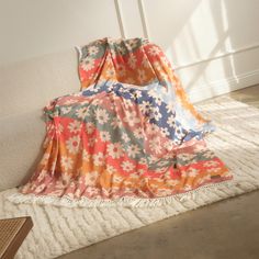 a blanket is laying on the floor in front of a wall with a window behind it