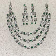 Emerald Necklace Set inspired by Sabyasachi, features a stunning green emerald paired with sparkling American diamonds and cubic zirconia.  Perfect for Indian weddings or special occasions, this statement piece adds a touch of elegance and luxury. An ideal gift for brides, it's a beautiful addition to any jewelry collection. *𝐏𝐑𝐎𝐃𝐔𝐂𝐓 𝐃𝐄𝐓𝐀𝐈𝐋* * 𝐌𝐚𝐭𝐞𝐫𝐢𝐚𝐥: Brass * 𝐏𝐥𝐚𝐭𝐢𝐧𝐠: White Rhodium Plated * 𝐒𝐭𝐨𝐧𝐞: AAA-quality CZ Diamond & Emerald. 𝐕𝐢𝐬𝐢𝐭 𝐎𝐮𝐫 𝐅𝐀𝐐𝐬 𝐟? Luxury Green Cutdana Jewelry Sets, Luxury Green Temple Necklace For Festive Occasions, Luxury Green Temple Necklace For Ceremonial Occasions, Luxury Green Diamond Necklace For Wedding, Luxury Green Round Bridal Necklace, Traditional Green Bridal Necklace With Diamond Accents, Green Wedding Necklaces With Sparkling Stones, Luxury Green Necklace For Wedding, Luxury Emerald Bridal Necklace For Wedding