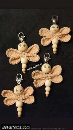 three crocheted angel key chains with buttons on them