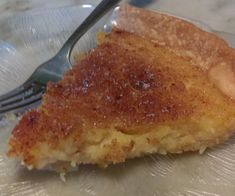 a piece of pie sitting on top of a glass plate with a fork in it