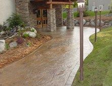 a house with stone pillars and landscaping in the front yard