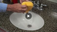 a person is cleaning a sink with a sponge