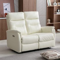 a white leather reclining loveseat in a living room