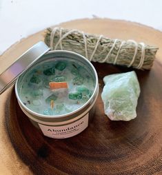 a cup of green liquid sitting on top of a wooden table next to a rock