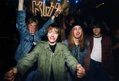 a group of young men standing next to each other in front of a neon sign