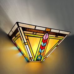 a stained glass light fixture on the wall