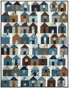 a quilt with many houses on it and one is blue, the other has brown