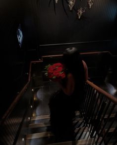 a woman sitting on top of a stair case holding a bouquet of flowers in her hand