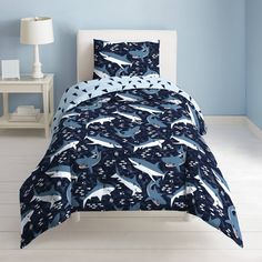 a bed room with a blue wall and a white headboard that has dolphins on it