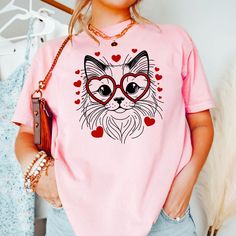 Embrace the Valentine's vibes with our adorable Ragdoll Cat Love Shirt! This heart-filled tee is purr-fect for Ragdoll cat moms and cat aficionados. Flaunt your love for your fluffy friend and spread the joy this Valentine's Day with a shirt that's as cute as it is comfortable. Ideal for a casual date, a day out, or snuggling with your kitty, it's a sweet addition to any cat lover's wardrobe. Gift it to a special someone who cherishes their Ragdoll or treat yourself to this charming expression of cat love. PRODUCT DESCRIPTION: The unisex heavy cotton tee is the basic staple of any wardrobe. It is the foundation upon which casual fashion grows. All it needs is a personalized design to elevate things to profitability. The specially spun fibers provide a smooth surface for premium printing vi Trendy Pink Cat Print T-shirt, Trendy Pink Tops With Cat Print, Trendy Pink Top With Cat Print, Kawaii Pink T-shirt With Cat Design, Kawaii Pink Cat Design T-shirt, Pink Kawaii Top With Cat Print, Cute Pink Cat Print T-shirt, Cute Pink T-shirt With Cat Print, Pink Cat Print Graphic Tee