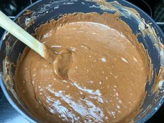 a wooden spoon in a metal bowl filled with batter