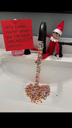 an elf is sitting in the sink with sprinkles