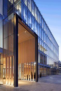 the entrance to an office building lit up at night with lights shining on it's windows