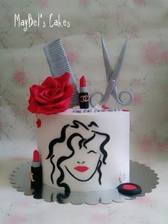 a cake decorated with lipstick, scissors and a rose