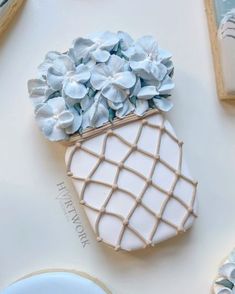 a cookie decorated like a vase with blue flowers on it and cookies in the background