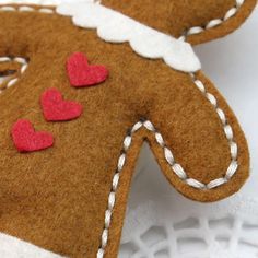 two gingerbread cookies with red hearts on them