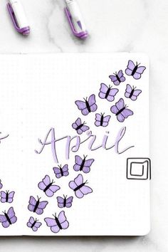 a notepad with purple butterflies and the word april written in cursive writing