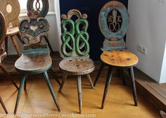 three old wooden chairs sitting next to each other on top of a hard wood floor