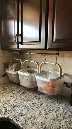 three baskets are hanging on the kitchen counter