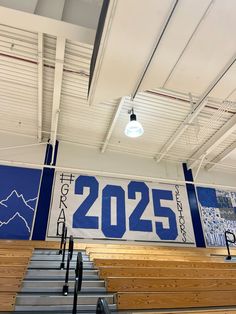 an empty gym with wooden seats and a large sign on the wall that reads 205