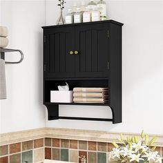 a black cabinet with towels and soaps on it