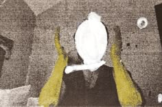 two hands holding up a white object in front of a black and white photo with yellow accents