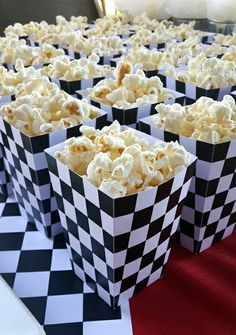 popcorn in black and white checkered paper bags on a table with red carpeting