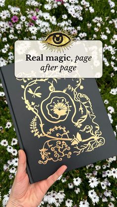 a person holding up a book with the title real magic, page after page