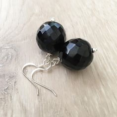 These handcrafted black onyx earrings are simply stunning! Silver fish hooks featuring a large 18mm round faceted black onyx gemstone and measuring 1.5 inches in length. Perfect for any formal occasion! Item is carefully packaged and shipped via USPS in a sturdy protective mailer. Check out more fabulous jewelry and enter my shop here: https://www.etsy.com/shop/jewelbytessyla View the positive feedback I've received from customers and check out some beautiful art prints for nursery and home at m Elegant Black Faceted Earrings, Black Faceted Earrings As A Gift, Faceted Black Earrings Gift, Handmade Black Sterling Silver Plug Earrings, Black Onyx Round Earrings, Black Dangle Plug Earrings As Gift, Black Sterling Silver Plug Earrings As Gift, Black Dangle Plug Earrings For Gift, Nickel-free Black Round Earrings