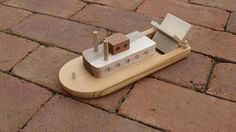 a toy boat sitting on top of a brick floor