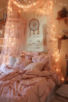 an unmade bed with fairy lights hanging from the headboard and curtains over it