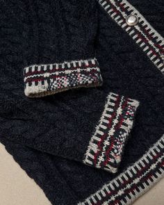 two pieces of knitted clothing laying on top of each other